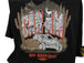 Black t-shirt with graphic design featuring text and illustrations of a deer, mountains, and a vehicle.